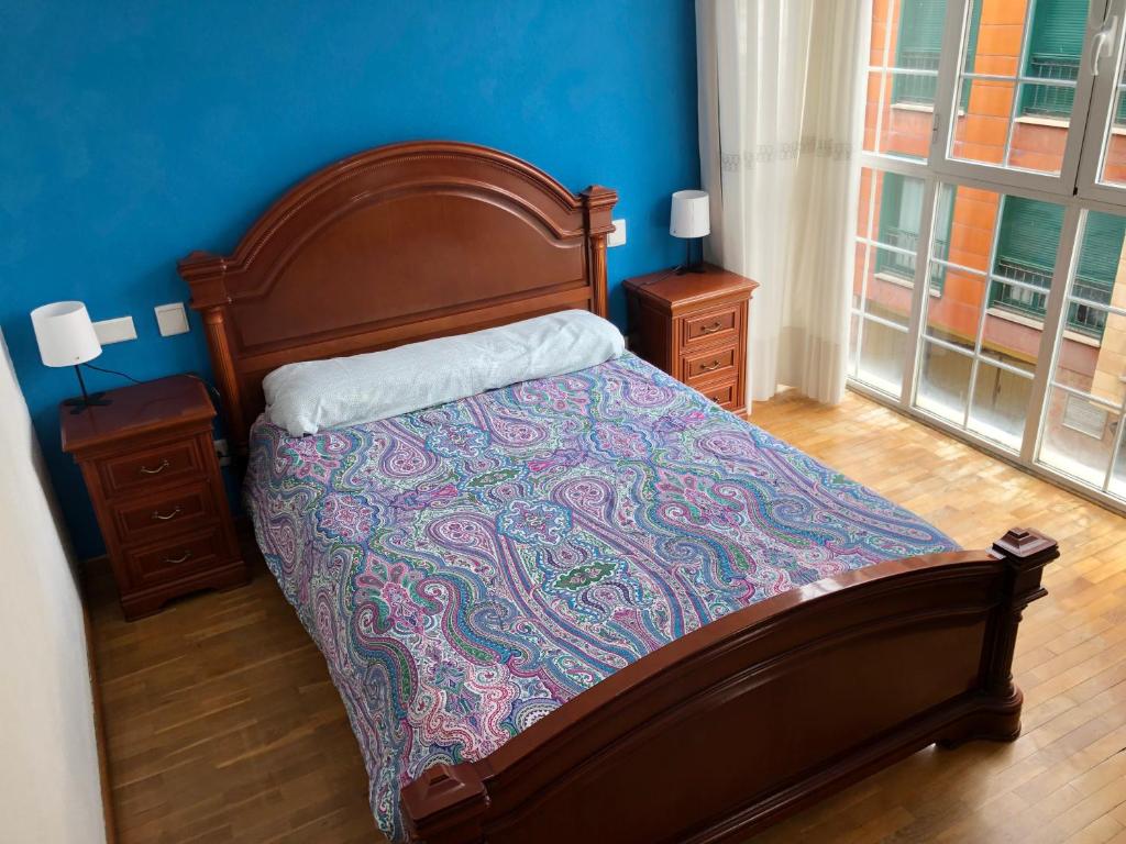 a bedroom with a bed and a blue wall at Villaviciosa in Villaviciosa