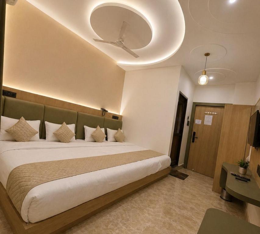 a bedroom with a large bed with a ceiling at New Skyrooms in Varanasi