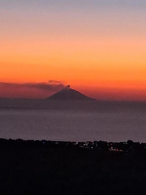 a sunset with a mountain in the background at Villette Pepe in Coccorino