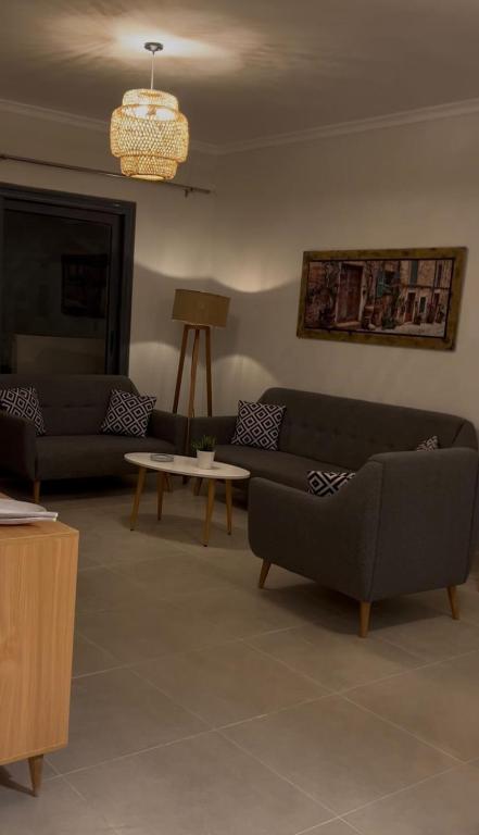a living room with two couches and a table at جايا راس الحكمه in Jalāl