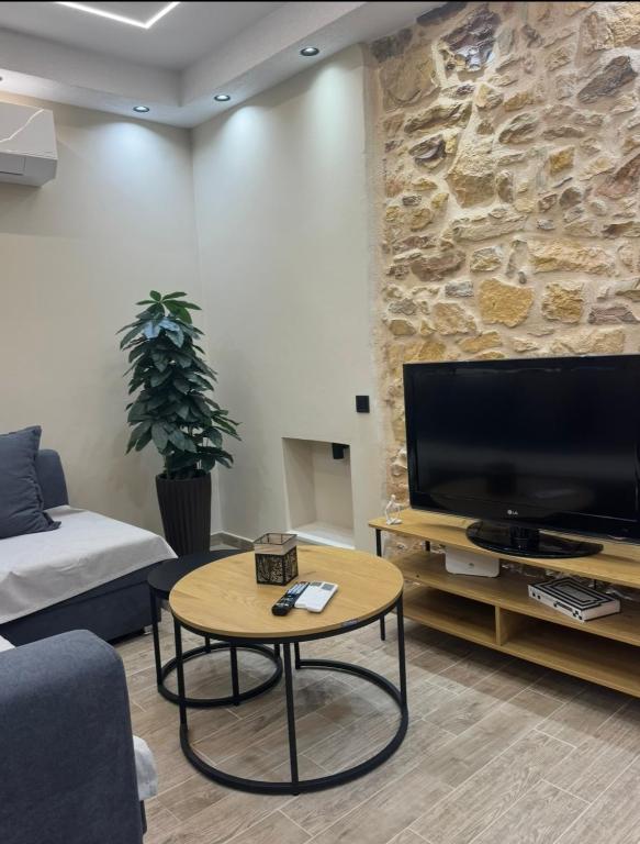 a living room with a tv and a coffee table at Downtown ViAlla Studio in Chios