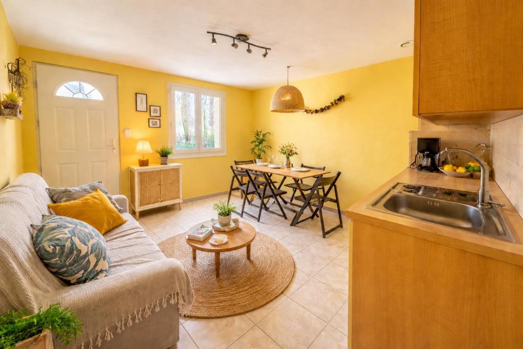 a living room with a couch and a kitchen at 45 Méditerranée in Ortaffa