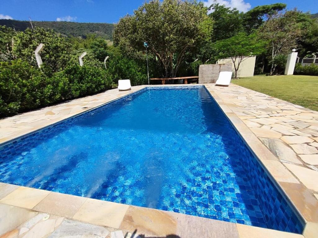 a swimming pool with blue water in a yard at Chácara Mative Socorro SP in Socorro
