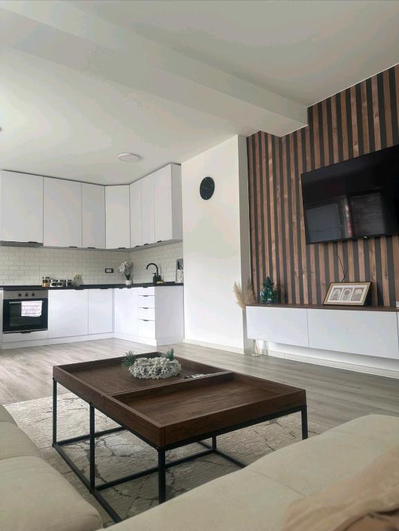 a living room with a table and a kitchen at Apartman Centar-moderan dvosoban stan u centru in Priboj