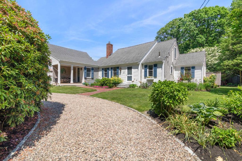 a white house with a gravel driveway at Heated Plunge Pool Theater Room Backyard Fun in Orleans