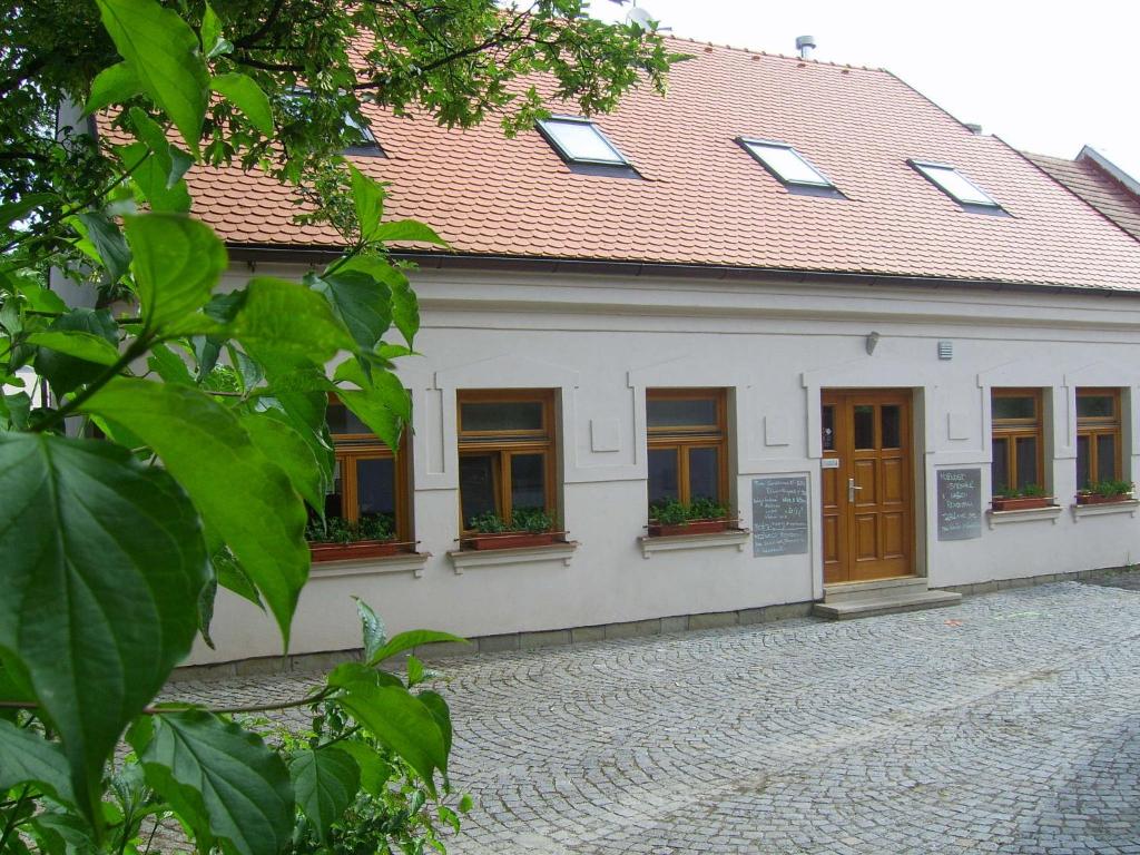 un bâtiment blanc avec un toit rouge dans l'établissement Penzion a CaféRestaurant U lávky, à Chrudim