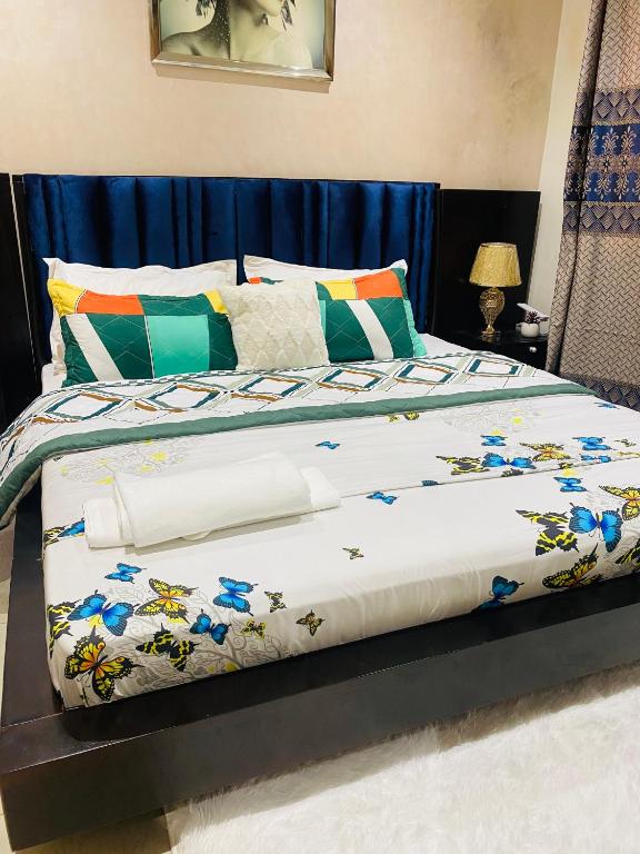 a bed with a comforter with flowers on it at Qlbs sweet room in Abidjan