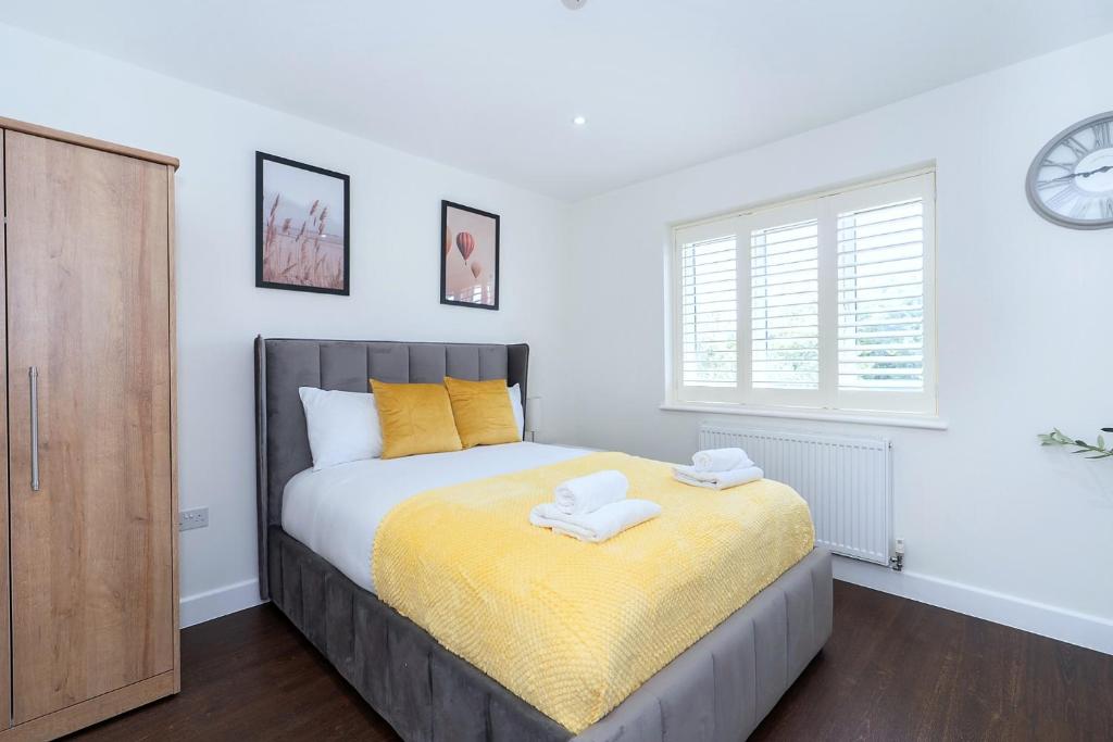 a bedroom with a bed with yellow sheets and a window at Open Mind Property - Ensuite Room Number 3 in Fareham