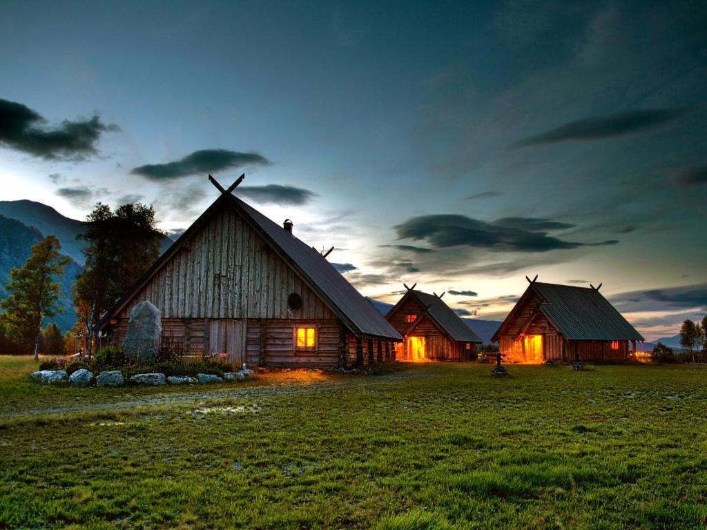 a couple of barns in a field at dusk at Viking Cabins - MIT FabLab - Solvik in Kvalvik