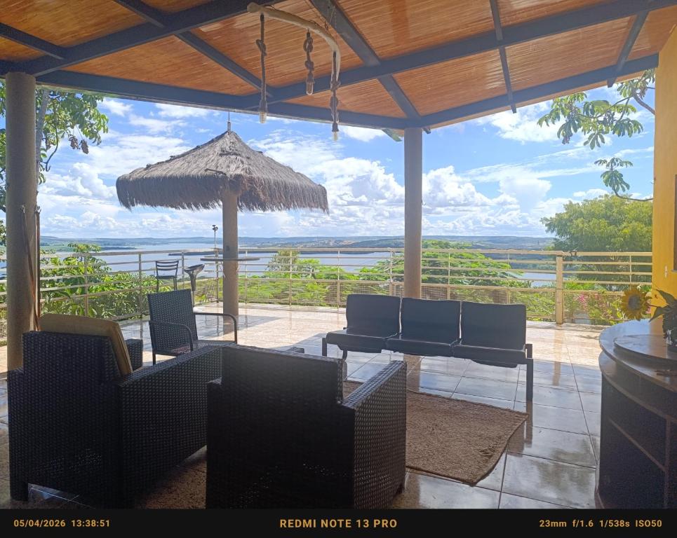 a patio with chairs and a table and an umbrella at Rancho Serra do Ouro in Alexânia