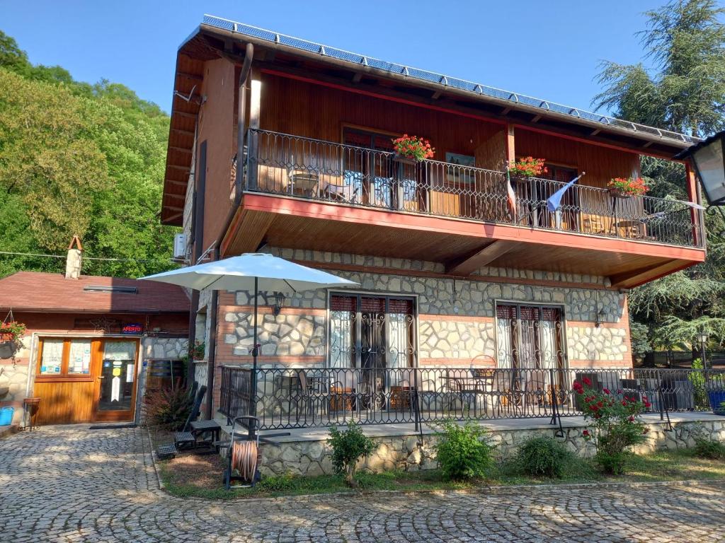 a building with a balcony and an umbrella at B&B Villa Tina in Alfedena