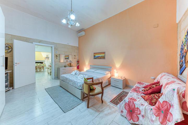 a bedroom with two beds and a table and a couch at Casa Relax vicino a Otranto in Giurdignano