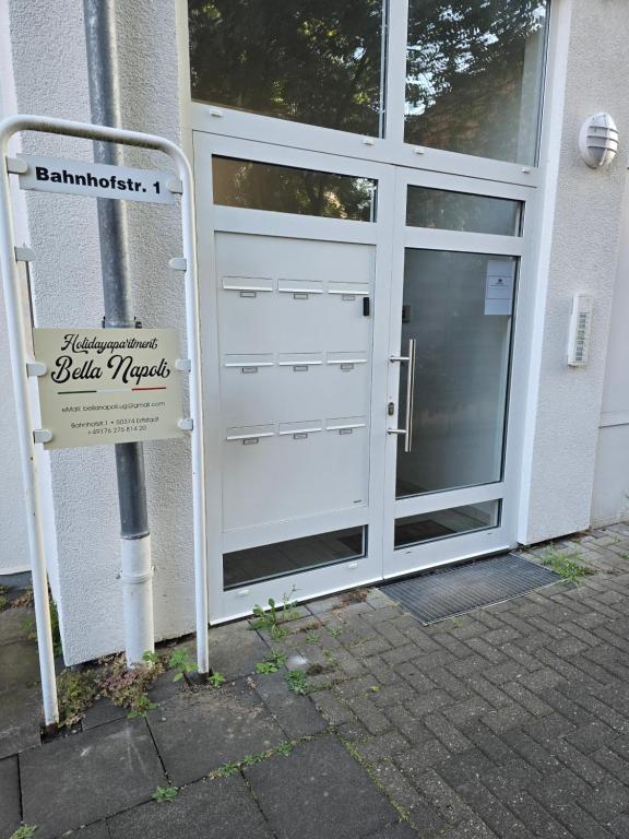 a white garage door with a sign in front of it at Holidayapartment Bella Napoli in Liblar