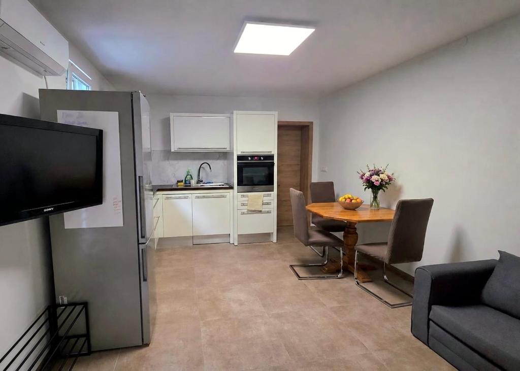 a living room with a table and a kitchen at Apartma Nad Klancem in Most na Soči