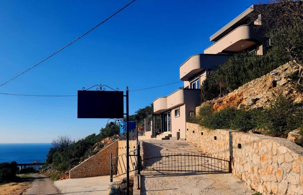 a building on a hill next to the ocean at Apartmani Zara in Pečurice