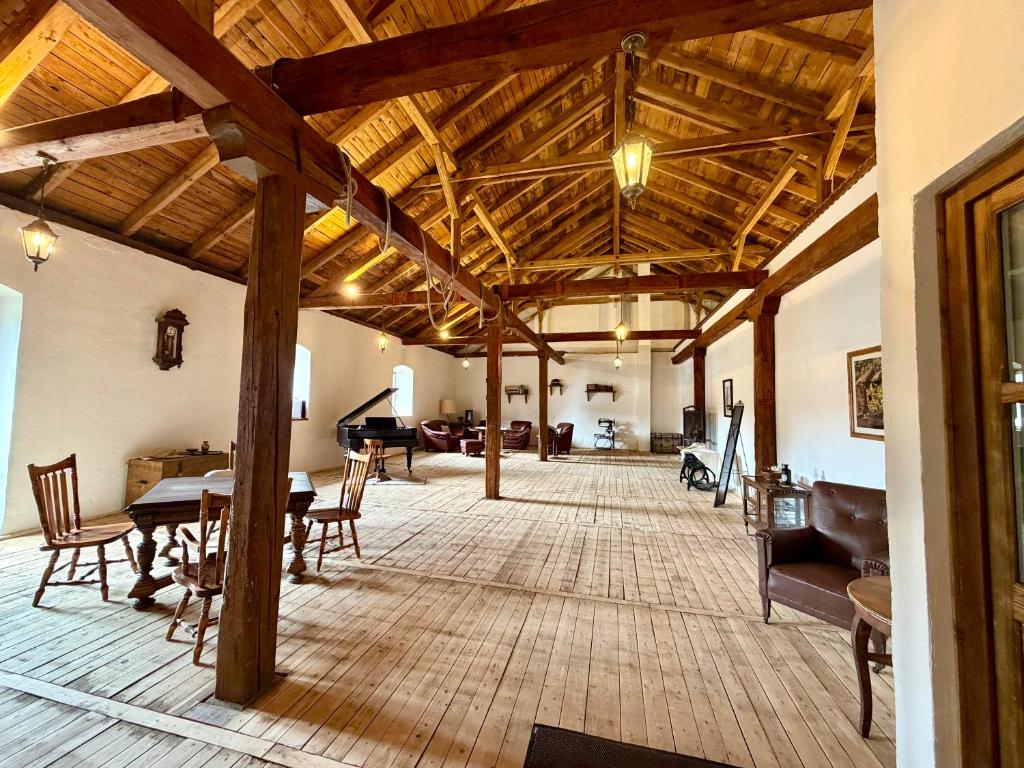 a large living room with wooden ceilings and a piano at Malom Loft Apartman in Veszprém