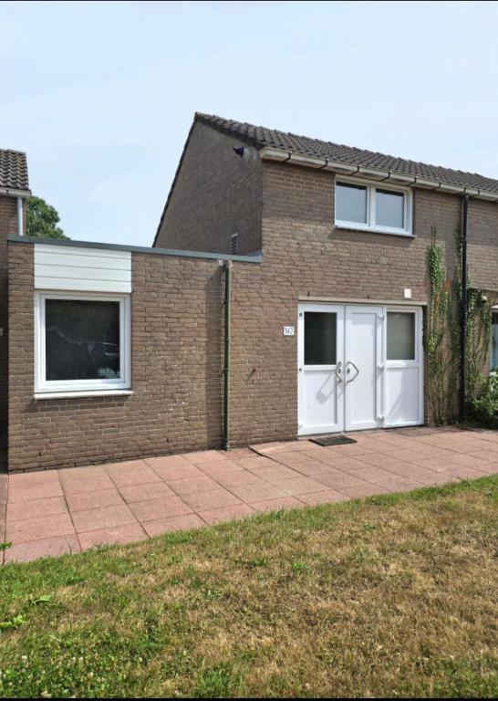 a brick house with two white garage doors at De Mossel 147 in Bruinisse