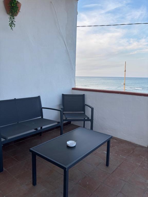 two chairs and a table on a balcony with the ocean at Terrazza delle Acacie in Villaggio San Leonardo