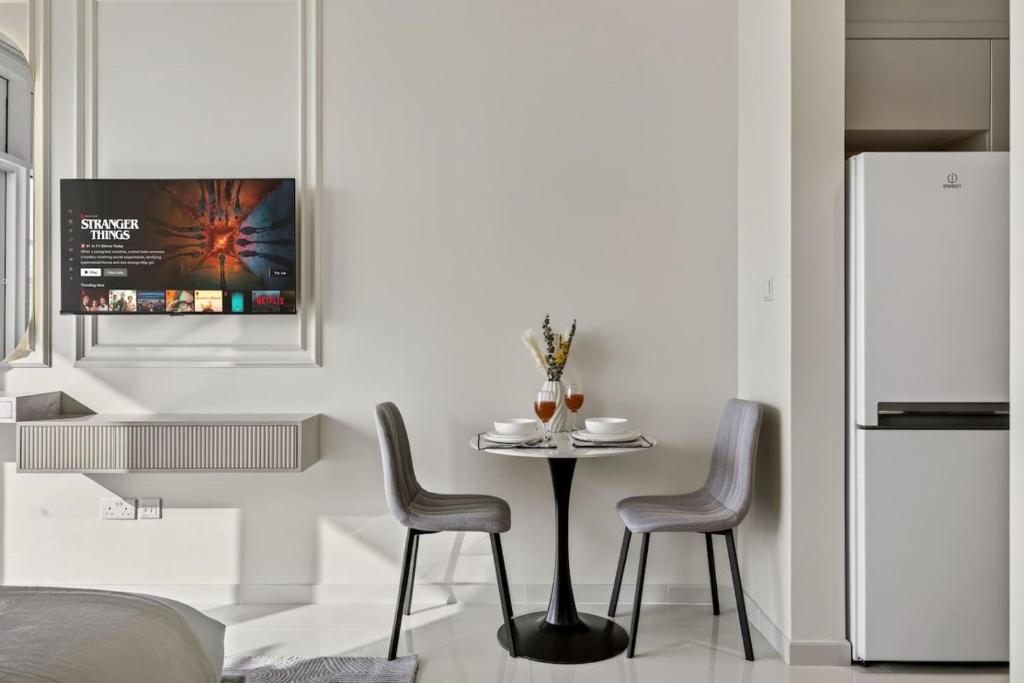 a kitchen with a table and two chairs and a refrigerator at FIRST CLASS Studio Inviting Luxury Escape in Dubai Marina