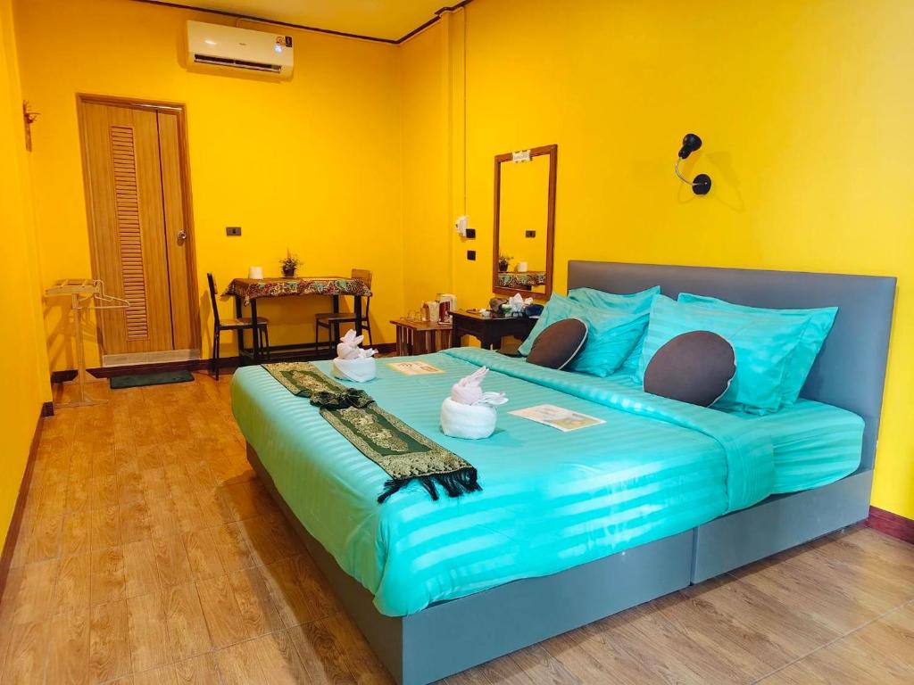 a bedroom with a large bed with blue sheets at Green Valley Lodge in Khao Sok National Park