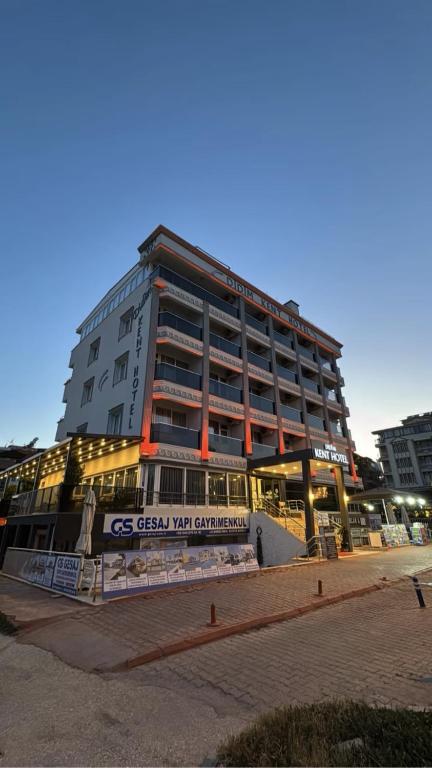 a tall building with a sign in front of it at KENT HOTEL Didim in Didim
