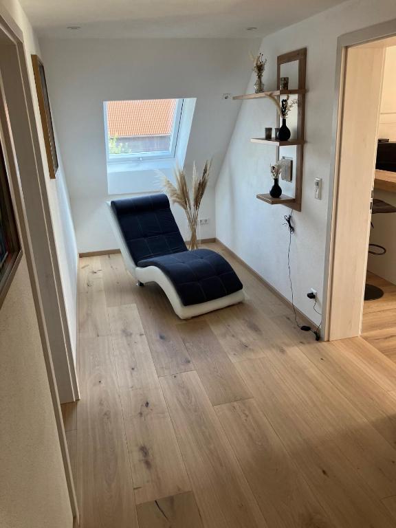 a blue chair sitting in the middle of a room at Ferienwohnung Unterallgäu in Markt Rettenbach