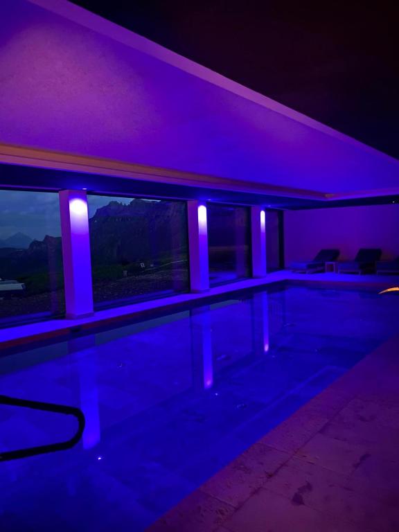 a swimming pool with purple lighting in a house at Hotel Savoia in Canazei
