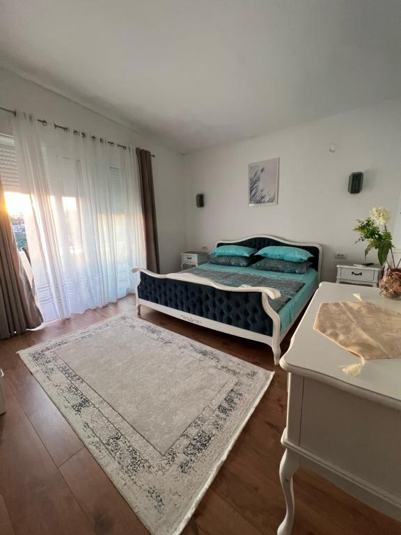 a bedroom with a bed and a table with a rug at Suka Apartments in Ulcinj