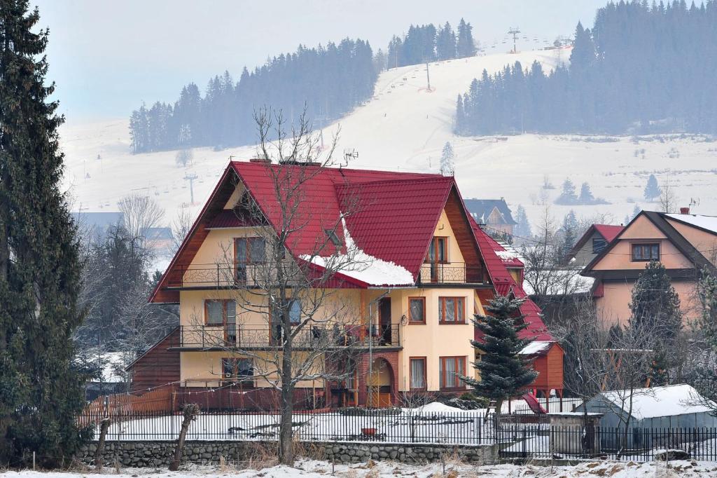 una casa con techo rojo en la nieve en Murań en Czarna Góra