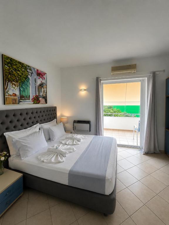 a bedroom with a large bed with a view of the ocean at Rethymno Blue Residence in Rethymno