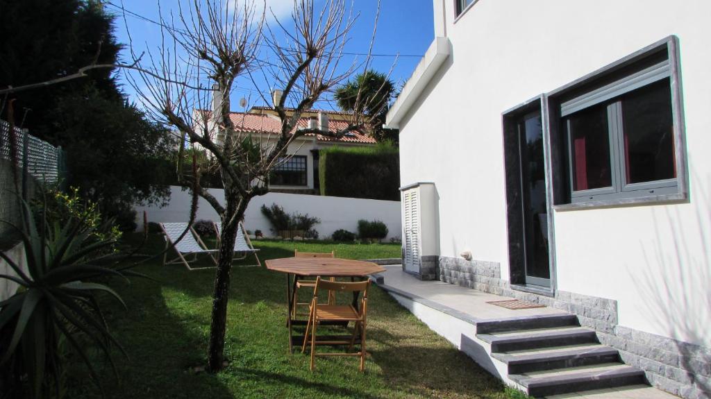 una mesa y sillas en el patio trasero de una casa en Moradia no Seixal Ericeira, en Ericeira