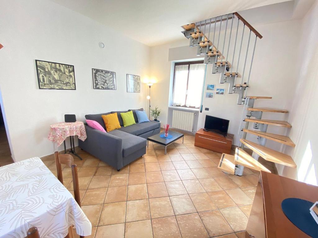 a living room with a couch and a spiral staircase at La DISCOGRAFICA, Spaziosa per Gruppi e Famiglie, vicina al Parco Acquatico Leolandia in Trezzano Rosa