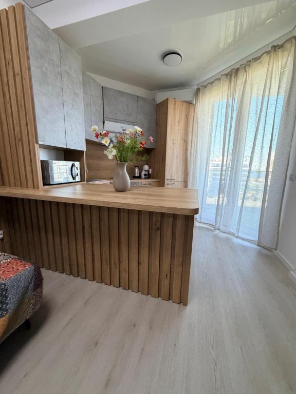 a kitchen with a counter with a vase of flowers on it at La Ion Residence 1 in Năvodari
