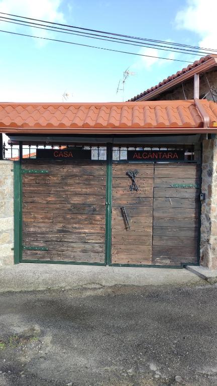 a pair of wooden garage doors on a building at Casa Alcántara in Vilamelle