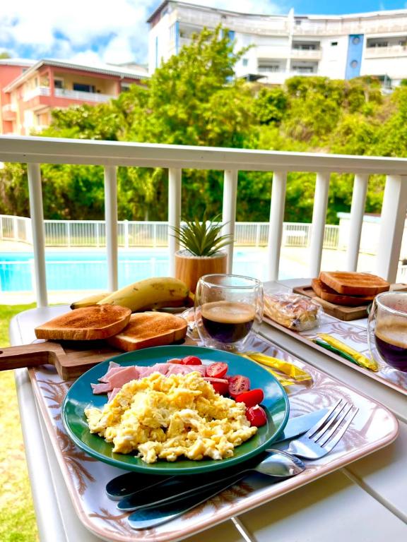 a plate of scrambled eggs and vegetables on a table at Le Cosy 888 Studio Plage 1 min Piscine Restaurants Casino in Les Trois-Îlets
