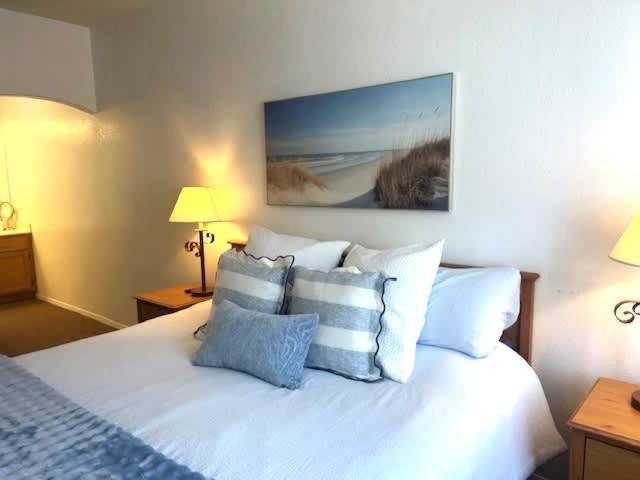 a bedroom with a bed with blue and white pillows at The Cottage on the Coast in Oceano