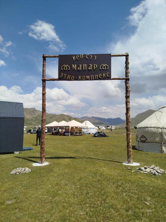 a sign for a market with tents in a field at Kel-Suu Manap in Kol-Suu