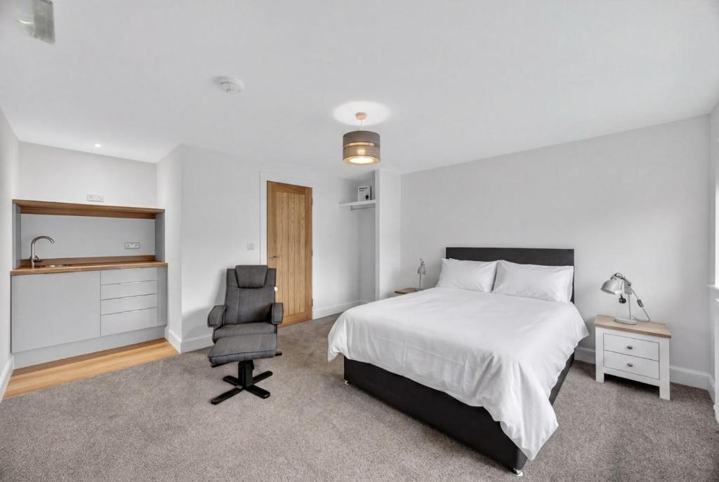 a bedroom with a bed and a desk and a chair at Stoney suites in Stonehaven