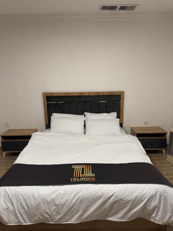 a large bed with a black and white comforter at Telimas tourism in Erbil
