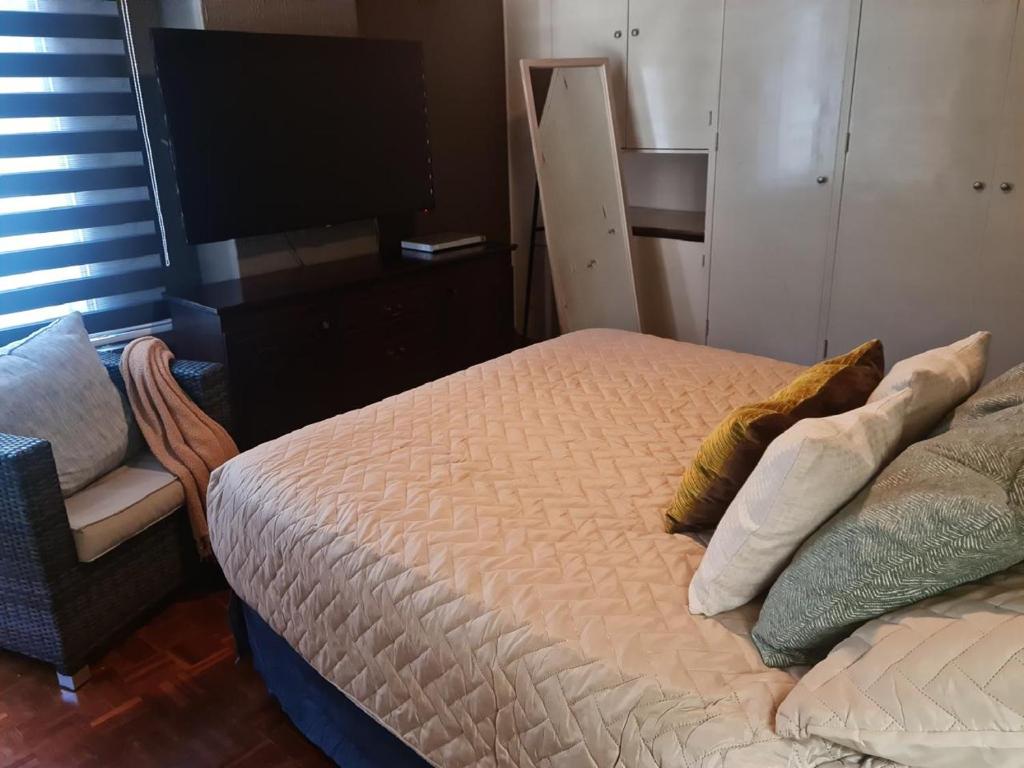 a bedroom with a bed and a chair and a television at Apartamento SC in Estación Pamplona