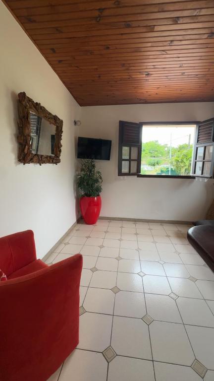 a living room with a red couch and a window at Kéra Lodge in Rivière-Pilote