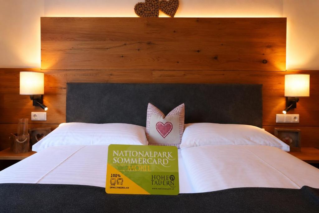 a hotel room with two beds with a sign on them at Hotel Bräu in Rauris