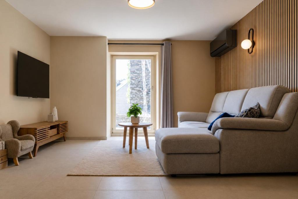 a living room with a couch and a window at L'aparté in Rochefort