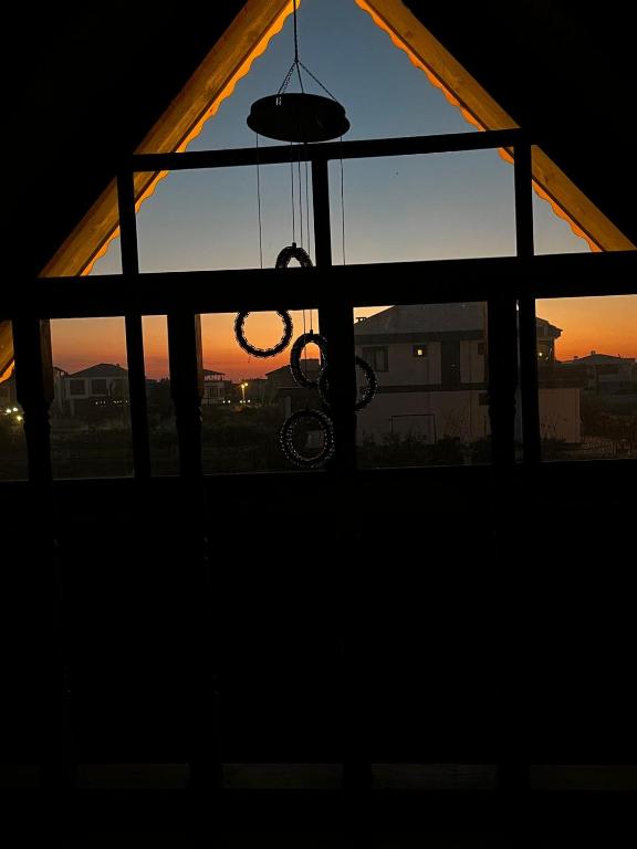 a window with a chandelier in front of a sunset at Bungavilla in Atakum
