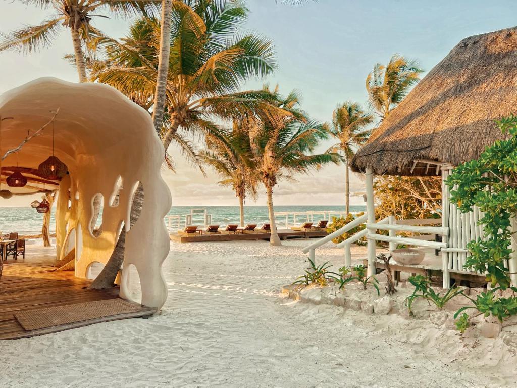a resort on the beach with palm trees and the ocean at Hotel Qamar in Tulum