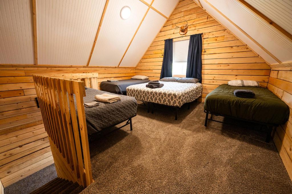 a room with three beds in a log cabin at Red Salmon Retreat, Cabin 8 at Lower Kenai Lodge in Kenai