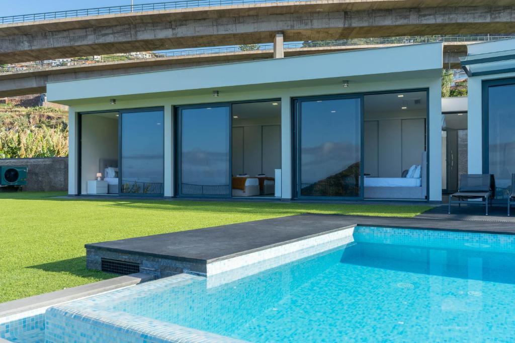 a house with a swimming pool in front of it at Luna Villa in Campanário