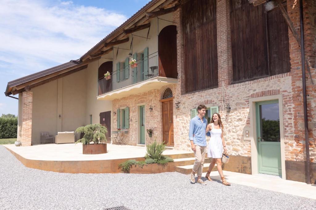 a man and a woman standing in front of a building at Cascina Bella - Piozzo in Piozzo