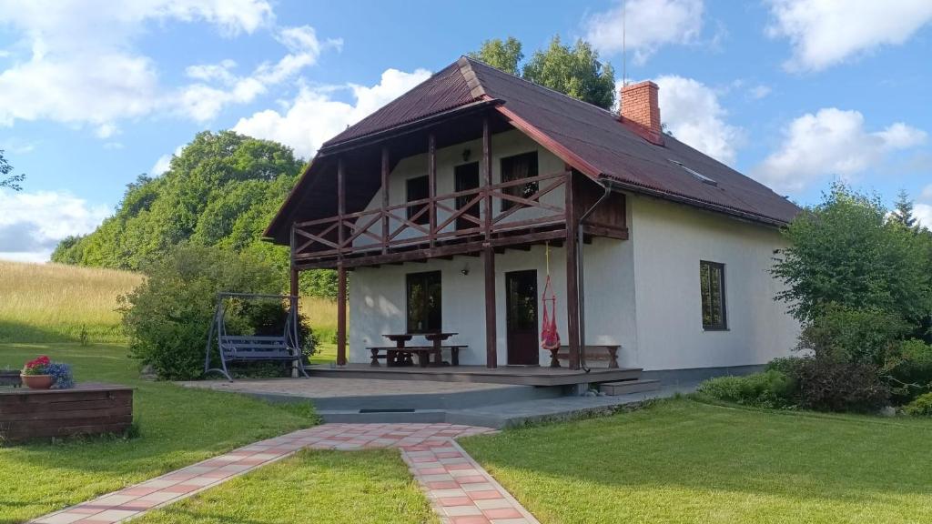 a white house with a picnic table in the yard at Kļūda 2 in Biksinīki