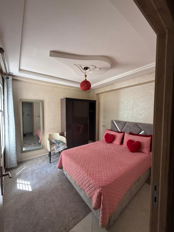 a bedroom with a bed with red pillows in it at Sunset Stay Anza in Agadir